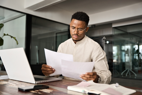 Image of man looking over papers that needs Xact-Pros insurance claim management services.